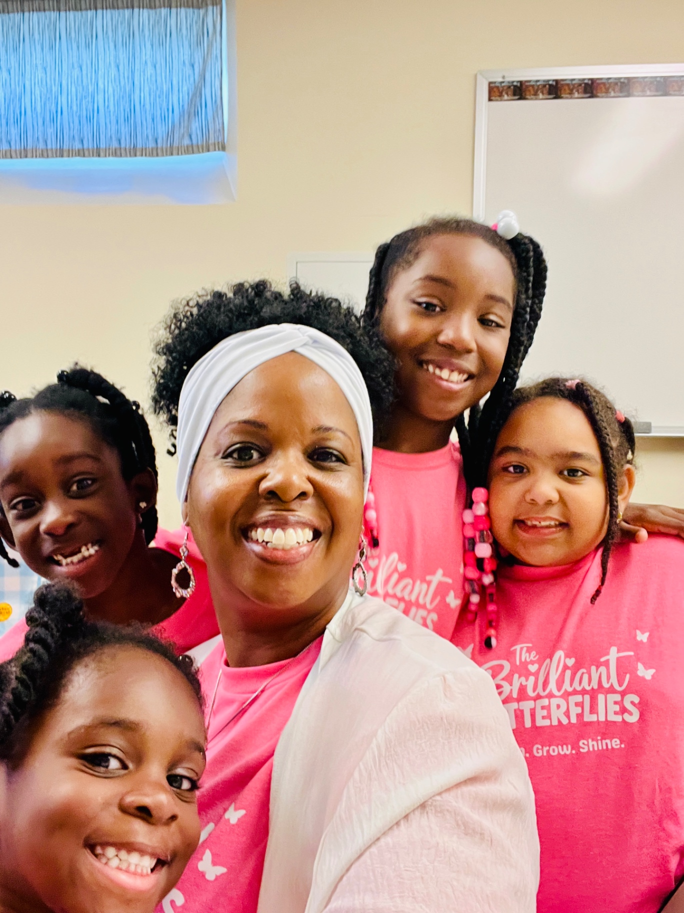 Tonya Hunt smiling with students from The Brilliant Butterflies summer program